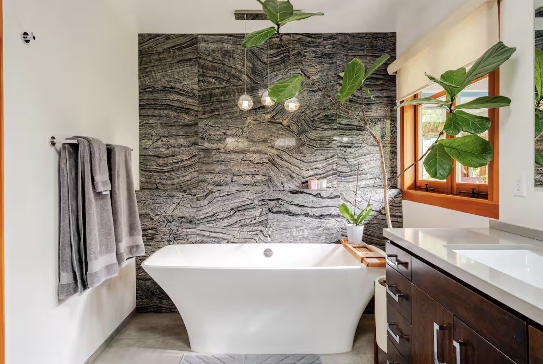 Dramatic stone wall bathroom with freestanding tub